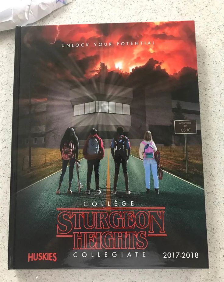 a book on the floor with three people standing in front of an orange and black building