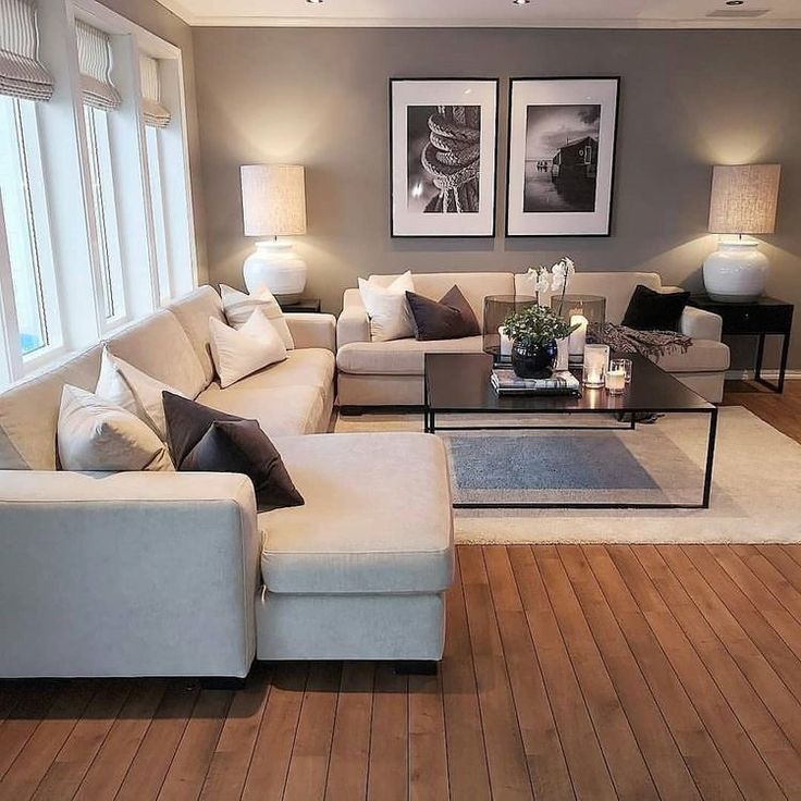 a living room filled with lots of furniture and decor on top of a hard wood floor