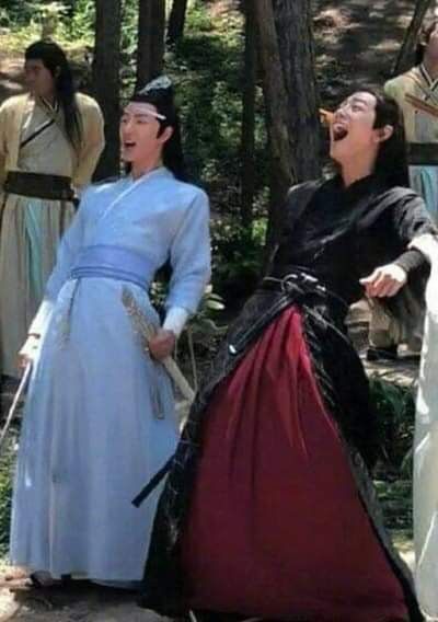 three people dressed in period costumes singing and laughing