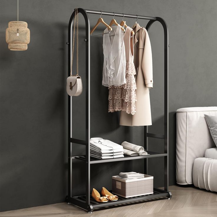 an iron rack with clothes hanging on it in a living room next to a white couch