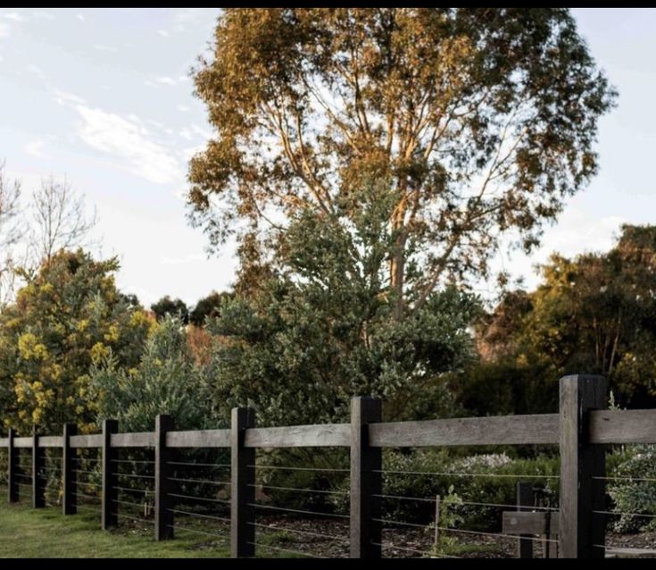 a wooden fence in the middle of a field