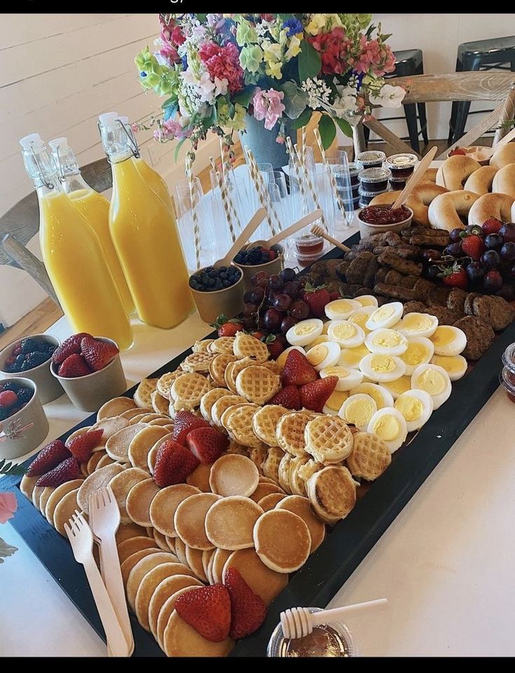 a table filled with waffles, strawberries and orange juice for breakfast or brunch