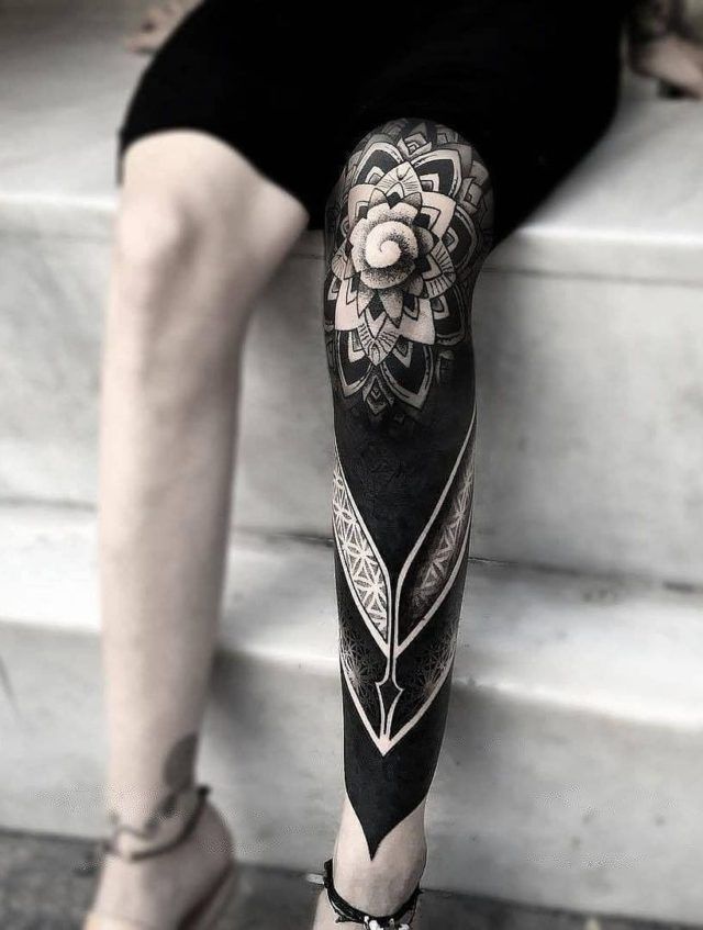 a person sitting on some steps with a tattoo on their arm and leg that has a flower in the middle