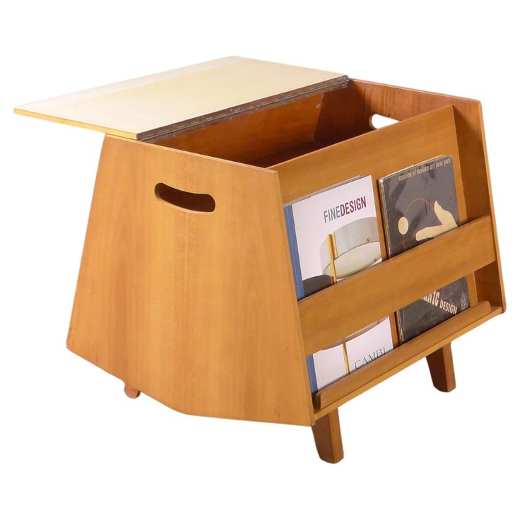 a wooden magazine rack with two magazines in it and a book shelf on one side