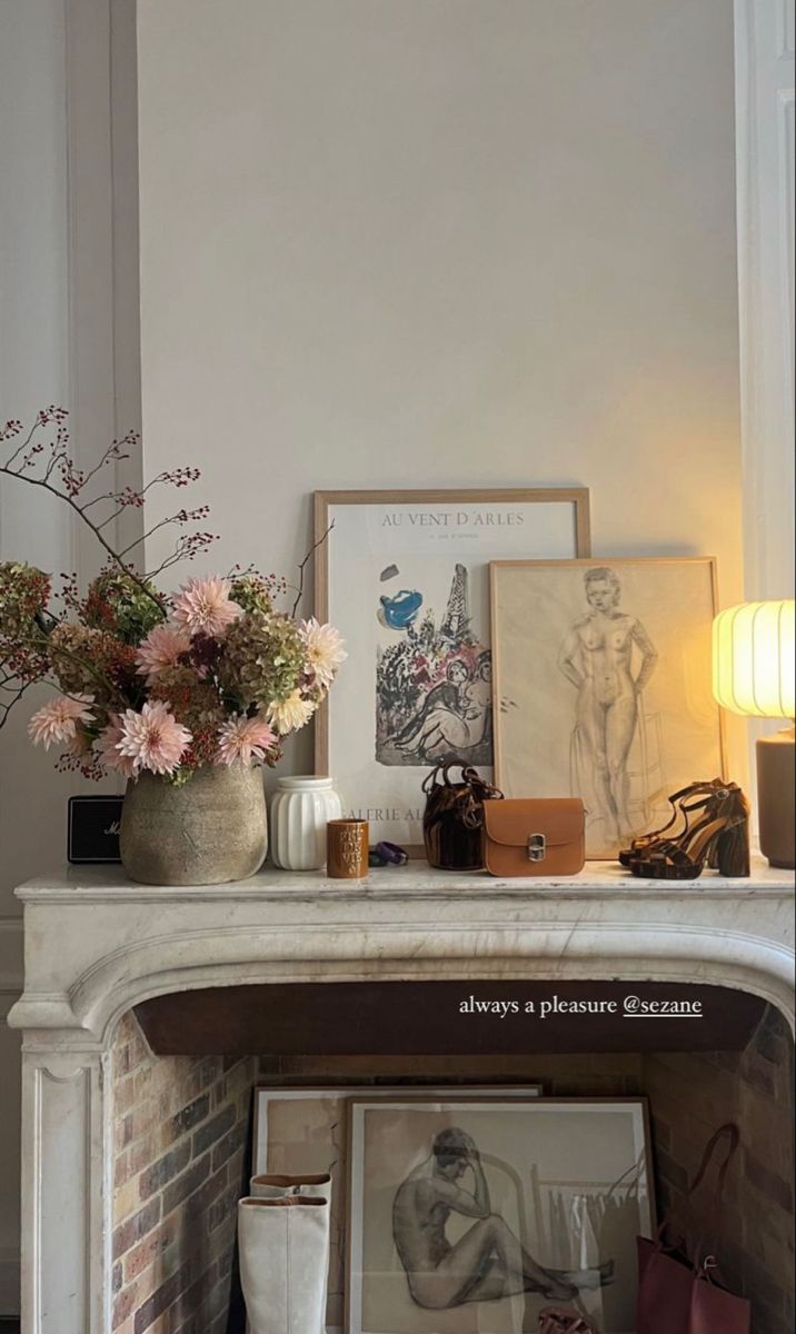 a fireplace with flowers and pictures on it