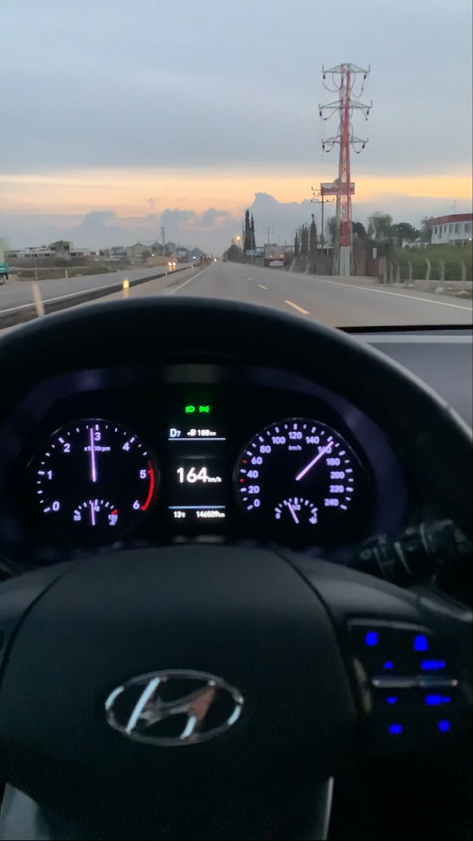 the dashboard of a car on a highway with lights and speedometers in view