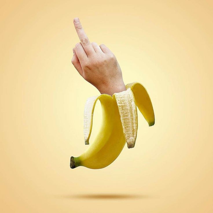 a banana being held up in the air by a person's hand and pointing at it