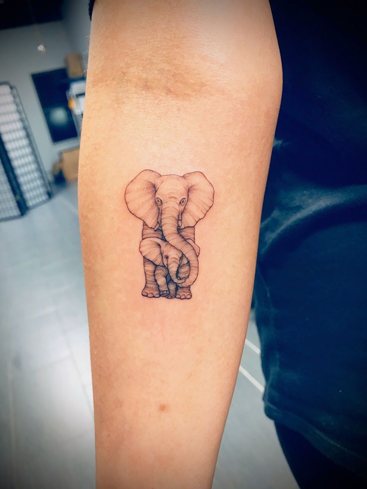 an elephant tattoo on the left arm