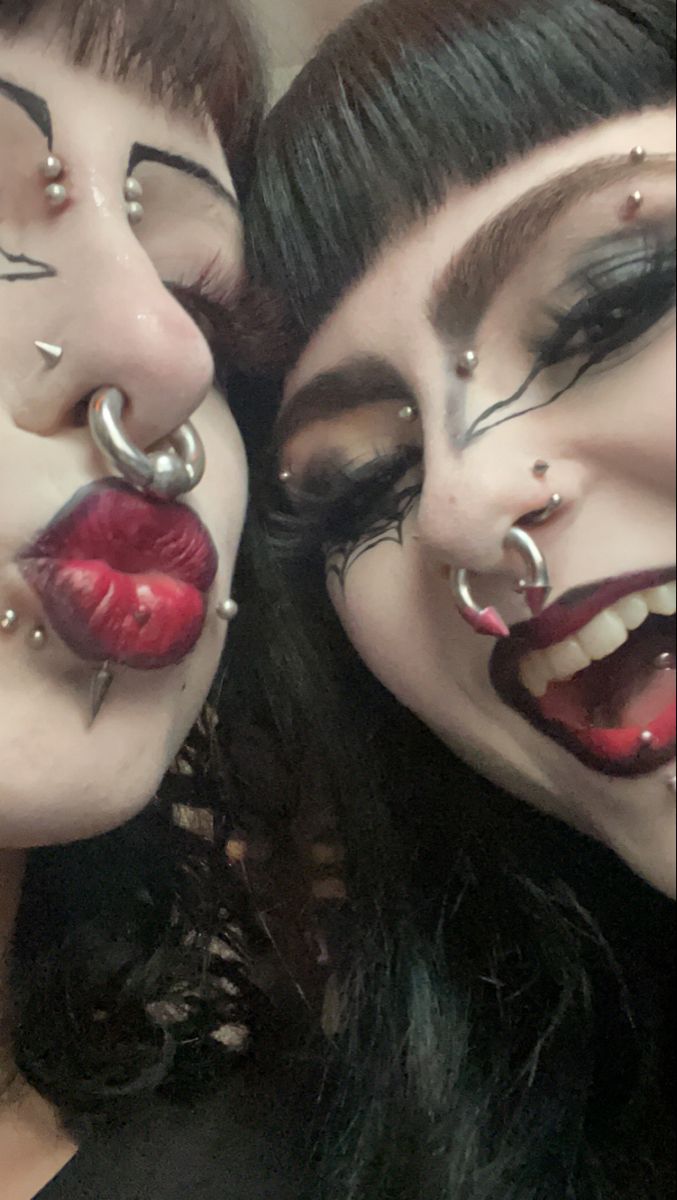 two women with fake nose rings and piercings on their mouths are posing for the camera