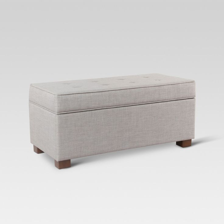 a white ottoman with wooden legs and an upholstered seat