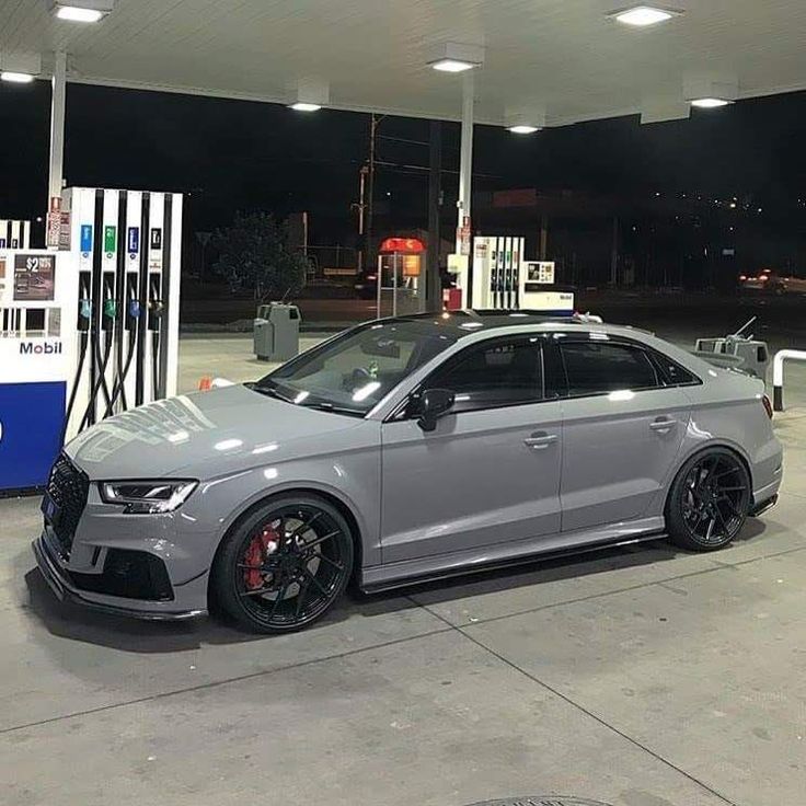 a grey car parked in front of a gas station