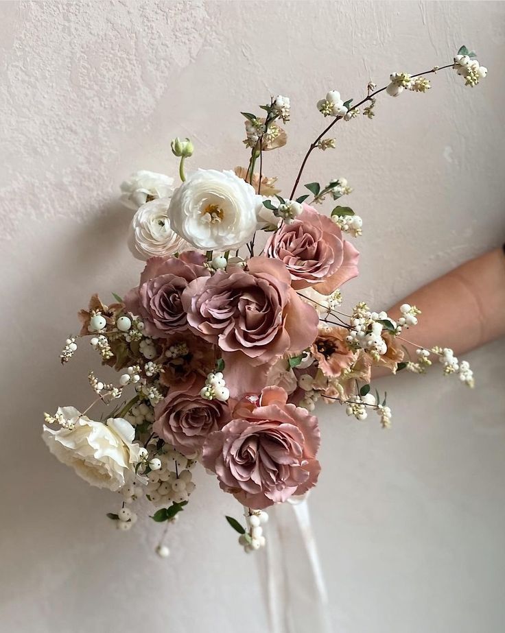 a person holding a bouquet of flowers in their hand