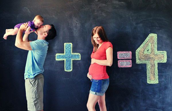 a man and woman standing in front of a blackboard with numbers on it