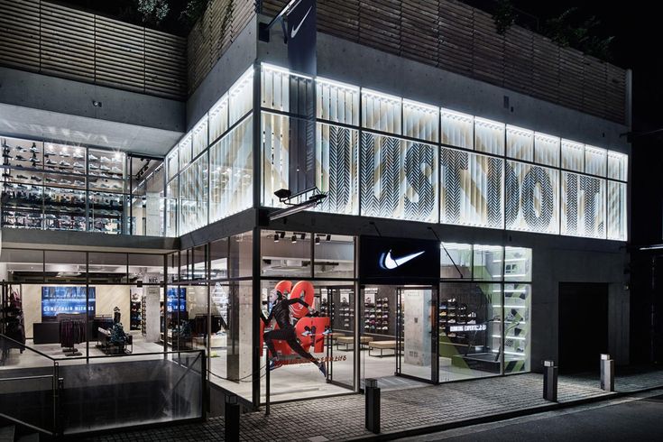 the nike store is lit up at night, with its lights on and it's doors open