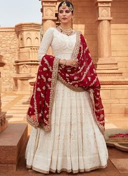 a woman wearing a white and red lehenga