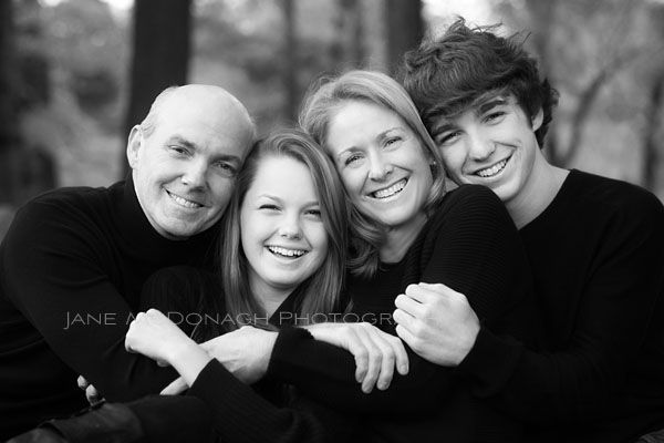 black and white photograph of three people smiling for the camera with their arms around each other