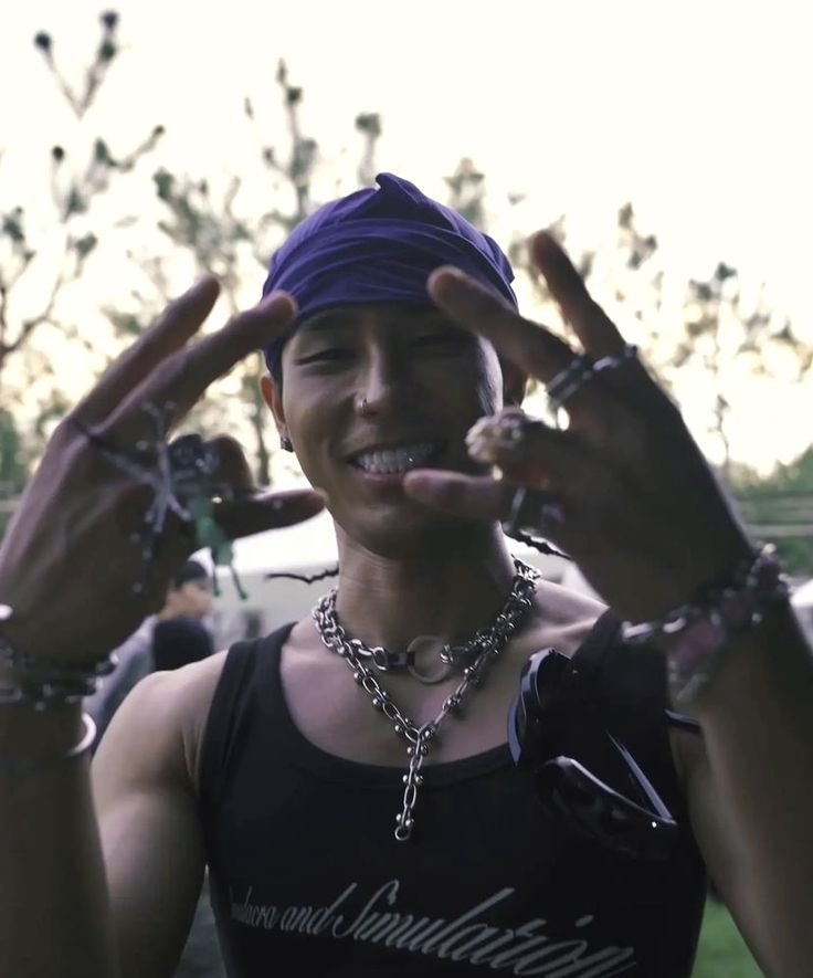 a person with two fingers up in the air and wearing a bandana on their head