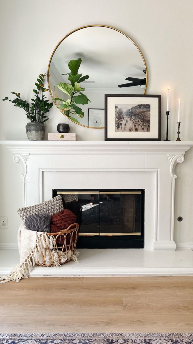 a living room with a fire place and pictures on the mantle