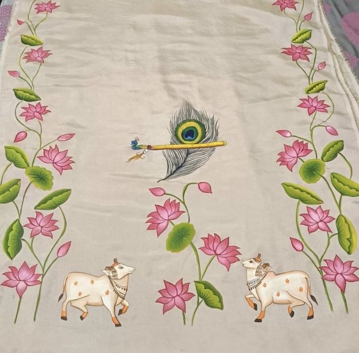 an embroidered table cloth with flowers and animals on it, in front of a peacock feather