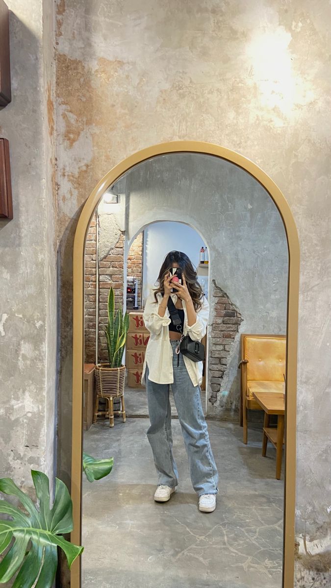 a woman taking a selfie in front of a mirror