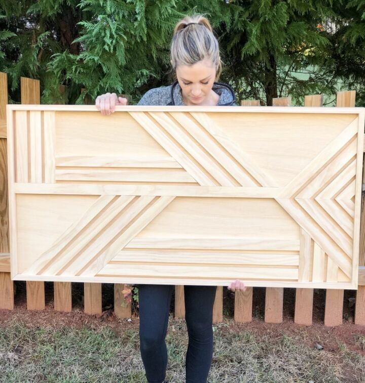 a woman holding up a large wooden box