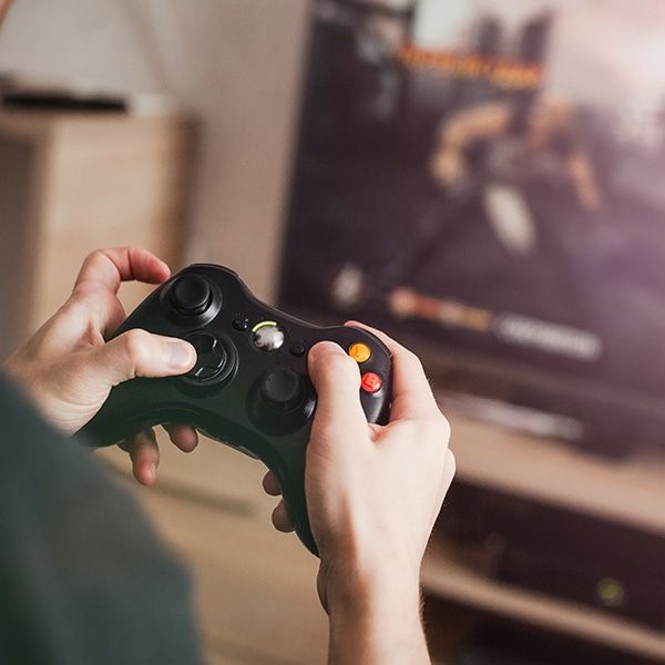 a person holding a video game controller in front of a tv