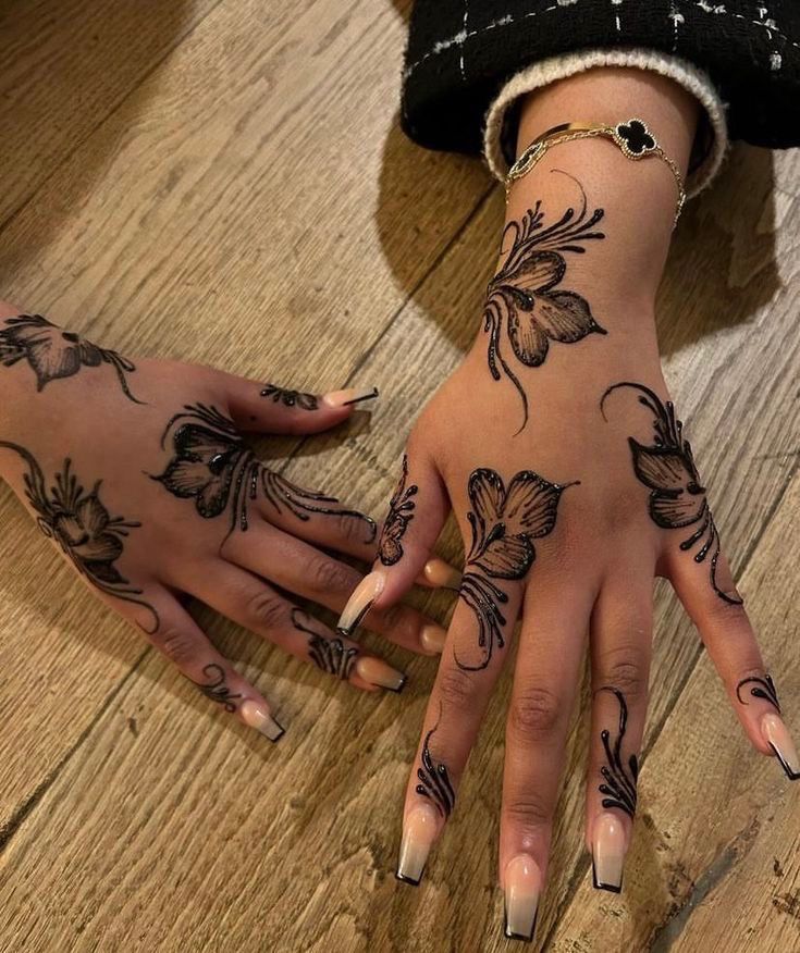 two hands that have tattoos on them