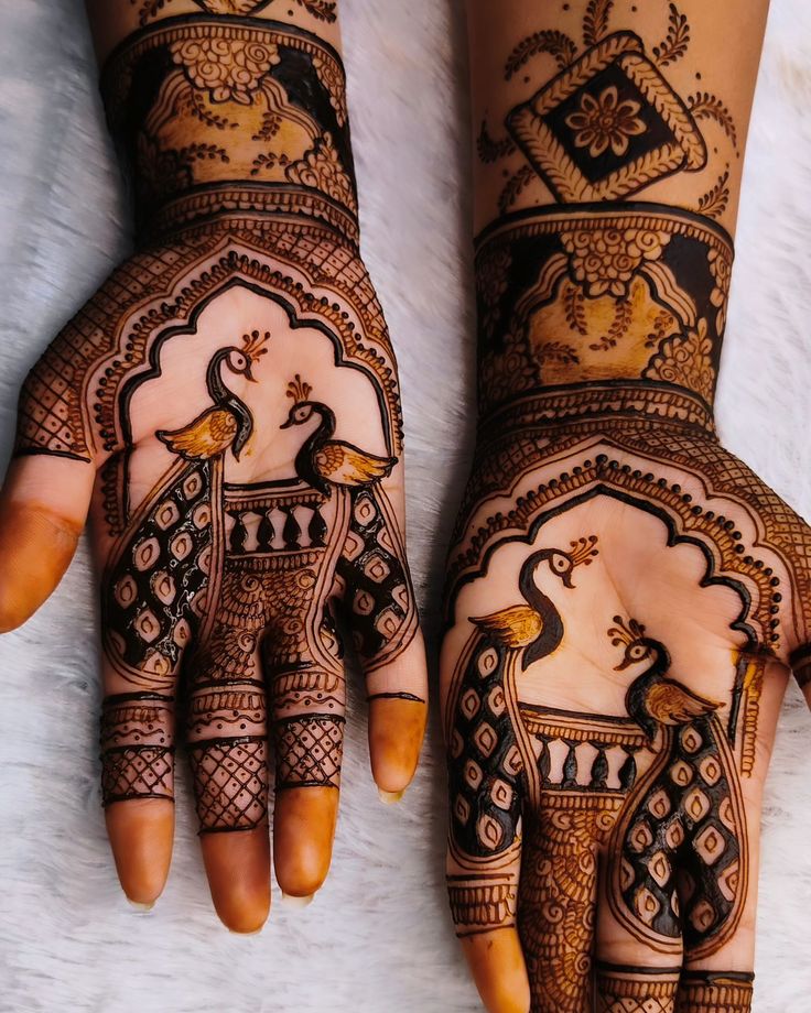 two hands with henna designs on them