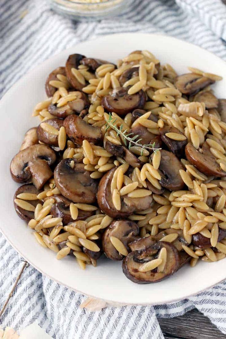 a white plate topped with pasta and mushrooms