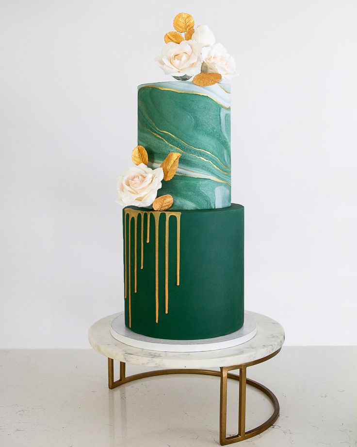 a green and gold cake with flowers on top