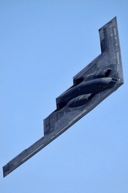 a fighter jet flying through a blue sky