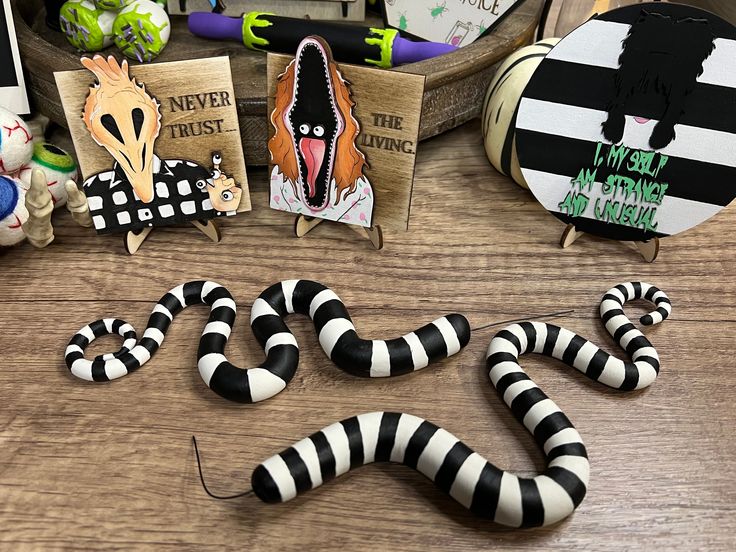 there are some fake snakes on the table next to books and magnets that say i'm not afraid to miss you