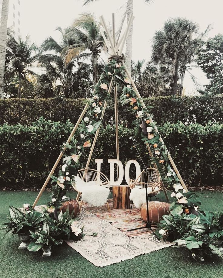 a teepee decorated with flowers and greenery