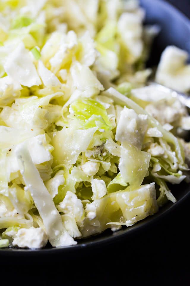 a close up of a plate of food with coleslaw and cheese on it