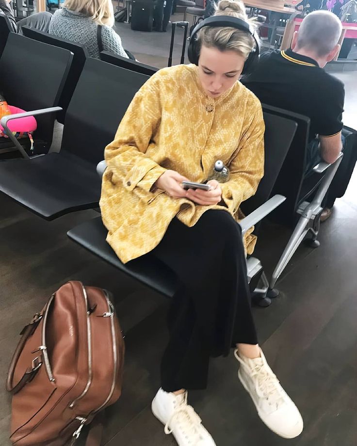 a woman sitting on a bench looking at her cell phone