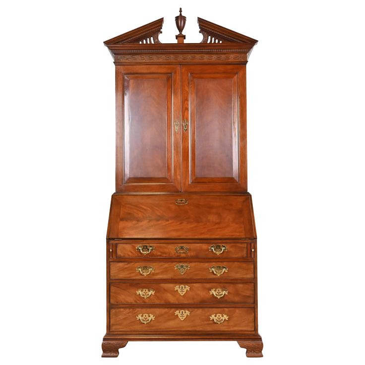 an antique wooden bureau with two doors and drawers