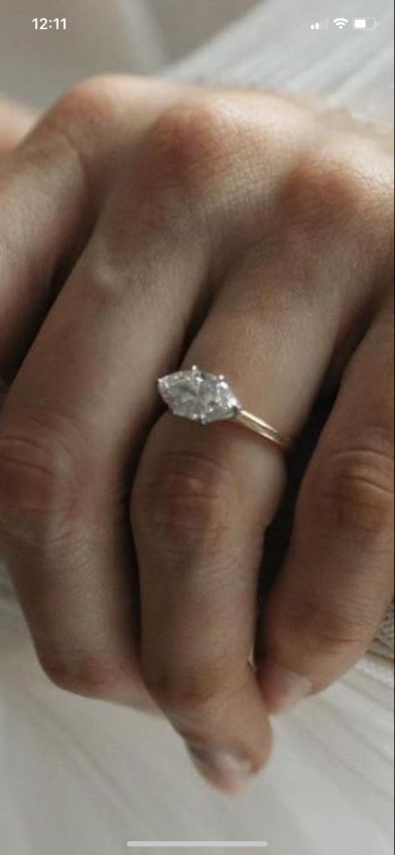 a woman's hand with a diamond ring on her left hand and the words first written below it