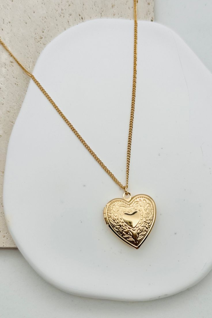 Get a heart-shaped locket necklace with a smooth finish for a vintage-inspired look. Keep your loved ones close to your heart (literally) with this charming accessory. 16" Chain + 3" Extender Charm: 1" x 1" Lobster Clasp closure Brass Shiny Gold Plating Heart Locket Necklace For Valentine's Day, Valentine's Day Heart Locket Necklace With Charm, Vintage Adjustable Heart Pendant Necklace, Vintage Heart Pendant Locket Necklace With Adjustable Chain, Heart Pendant Locket Necklace For Valentine's Day, Classic Pendant Locket Necklace For Valentine's Day, Valentine's Day Heart Pendant Locket Necklace, Vintage Personalized Open Heart Necklace, Personalized Vintage Open Heart Necklace