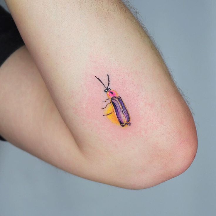 a small bug tattoo on the left side of someone's right arm and leg