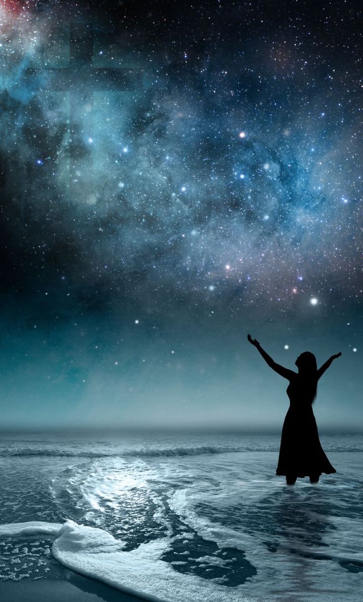 a woman standing in the water with her arms outstretched to the sky and stars above