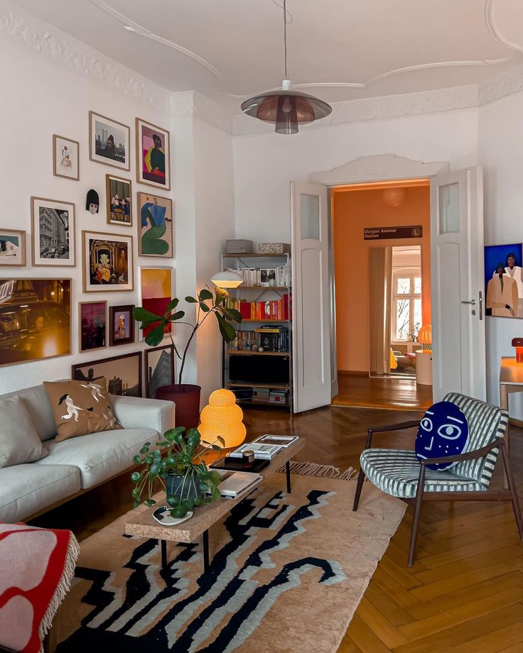 a living room filled with furniture and pictures on the wall