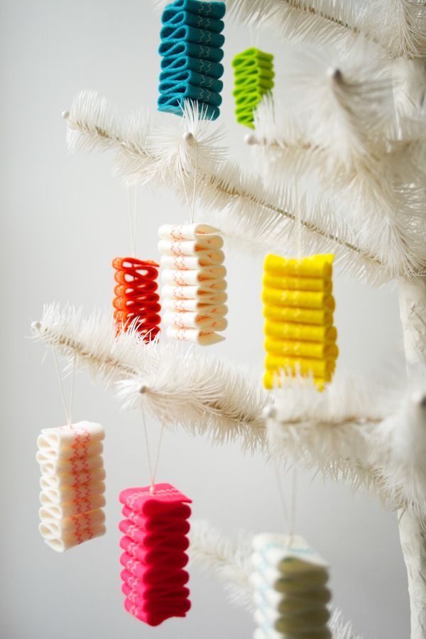 several different colored objects hanging from a white tree