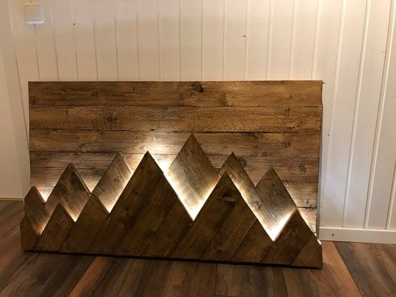 a wooden mountain sculpture on top of a hard wood floor