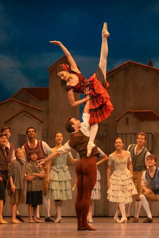 a group of people standing on top of each other in front of a stage with dancers