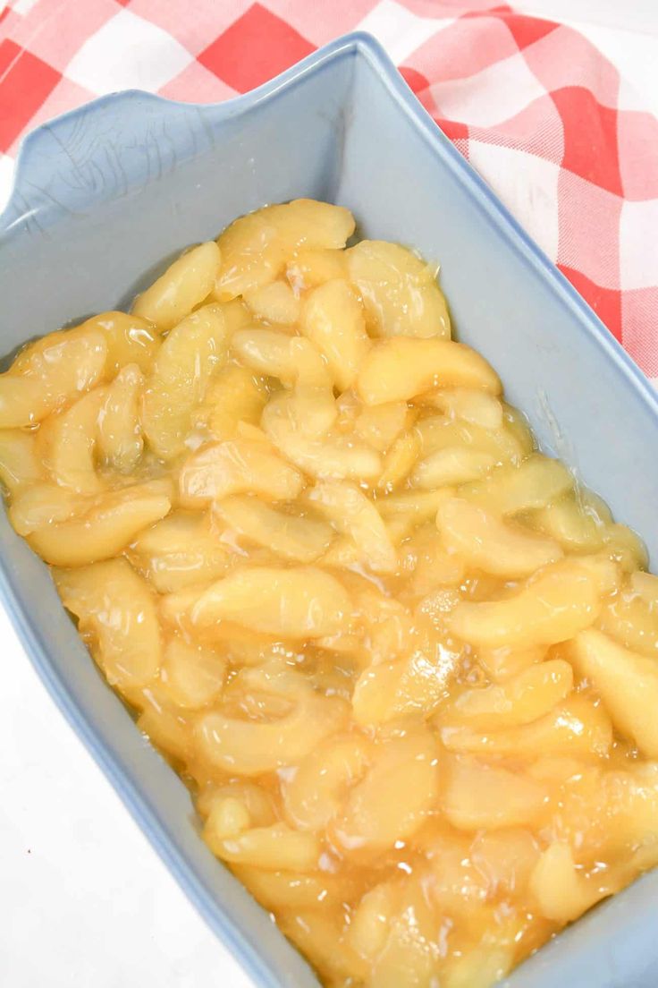 a casserole dish filled with macaroni and cheese on a checkered tablecloth