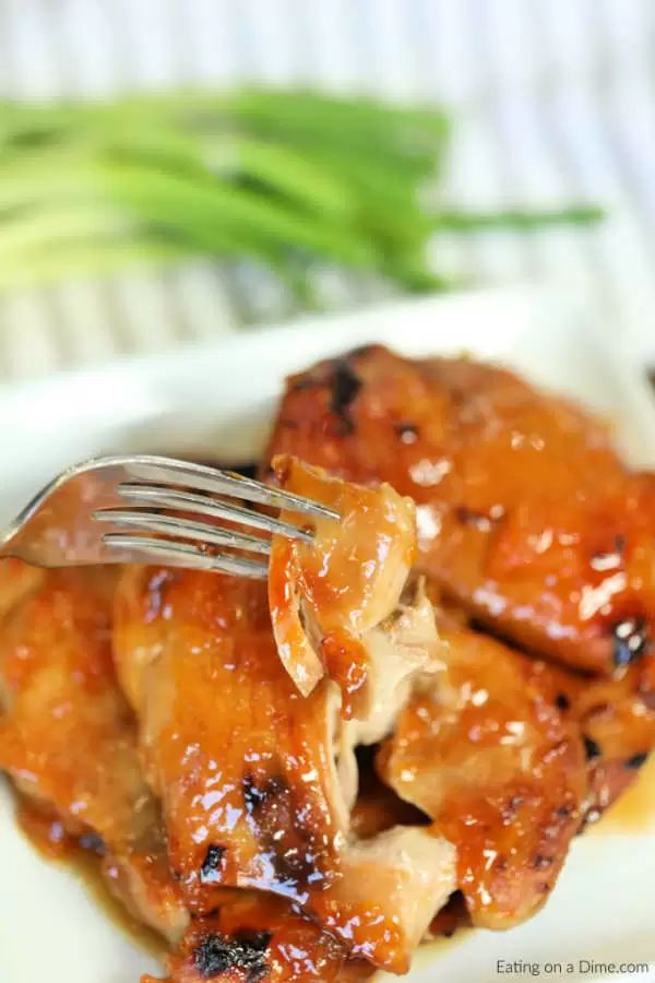 slow cooker apricot chicken on a white plate with a fork in it