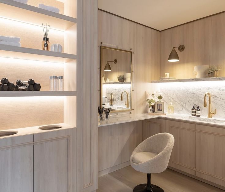 a white chair sitting in a kitchen next to a counter top and shelves with lights on it