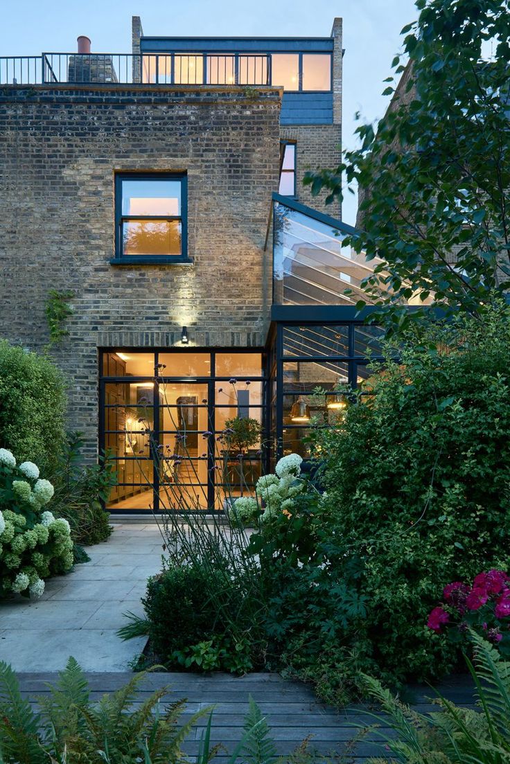 a brick building with lots of windows and plants around it