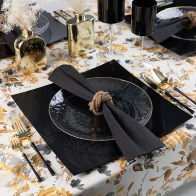 a place setting with black plates and napkins