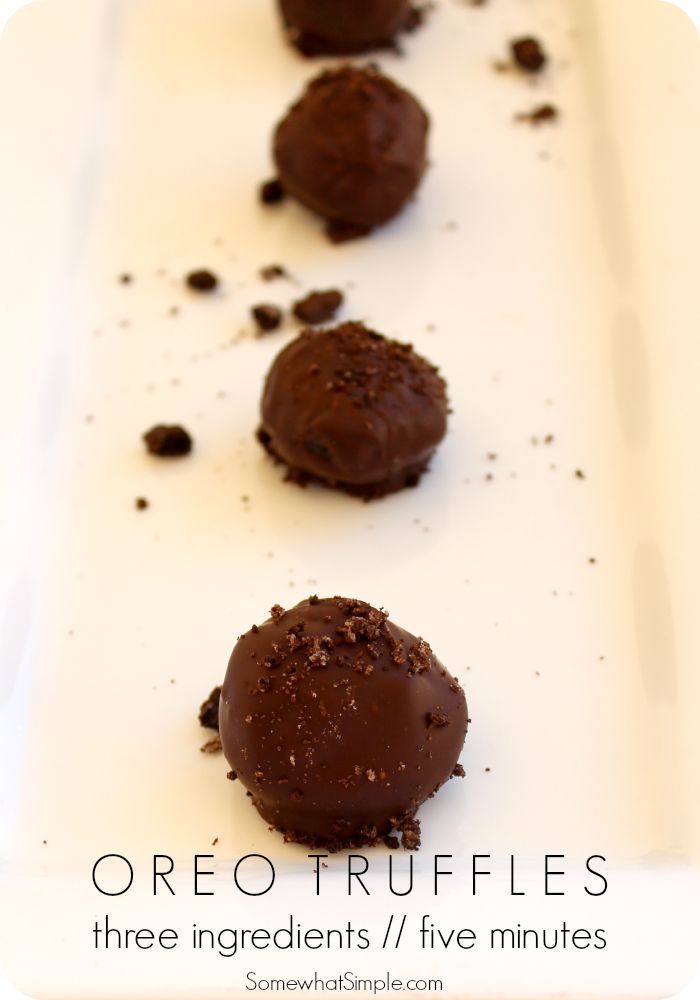 three chocolate truffles sitting on top of a white plate with dirt all over them